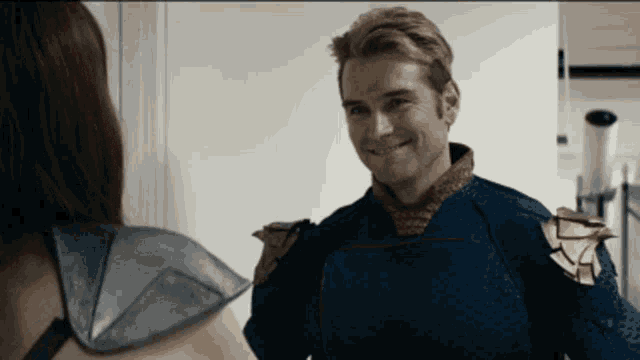 a man in a superhero costume is smiling and looking at a woman