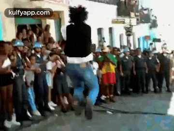 a man is jumping in the air in front of a crowd of police officers .