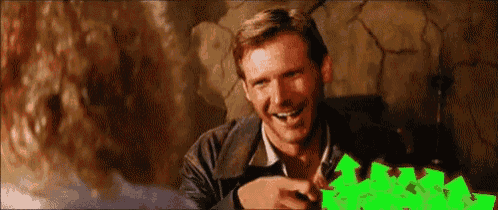 a man is sitting in front of a green screen and laughing .