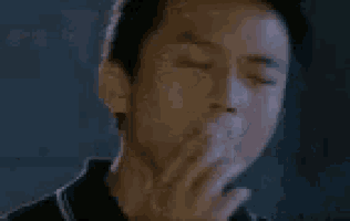 a close up of a man 's face in a dark room with a blurry background .