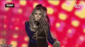 a woman is singing into a microphone on stage .