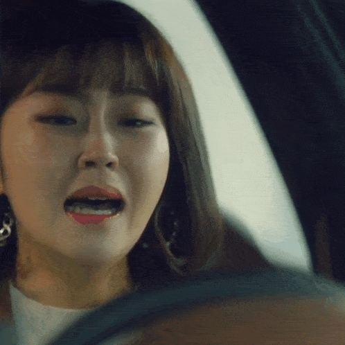 a close up of a woman 's face in a car with her mouth open
