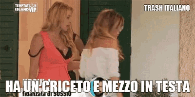 two women are standing next to each other in front of a door and talking .