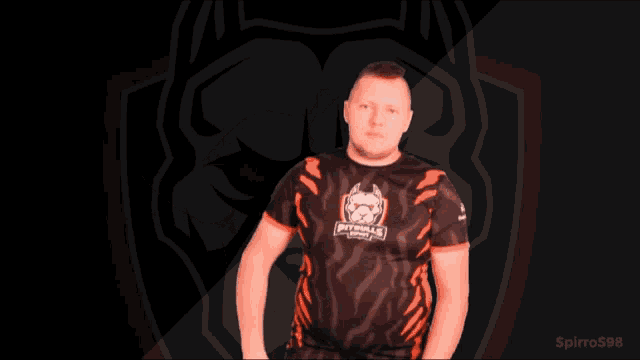 a man wearing a black and orange shirt with a logo on it