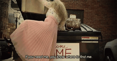 a woman in a pink dress is standing on top of a dumpster that says home me