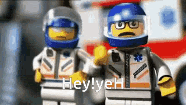 a couple of lego figures are standing next to each other and one of them is wearing a blue helmet .