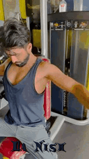 a man in a tank top is doing exercises in a gym with the name danish on the bottom right