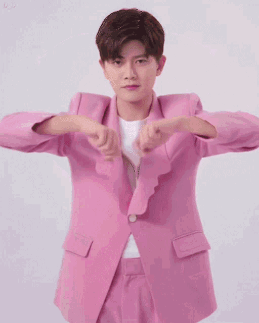 a man in a pink suit is holding a pink heart