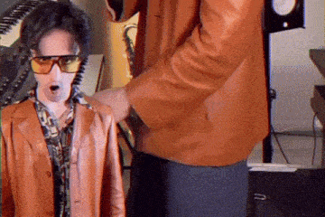 a man wearing sunglasses and a brown jacket