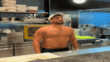 a shirtless man in a kitchen with a tattoo on his chest that says ' i love you '