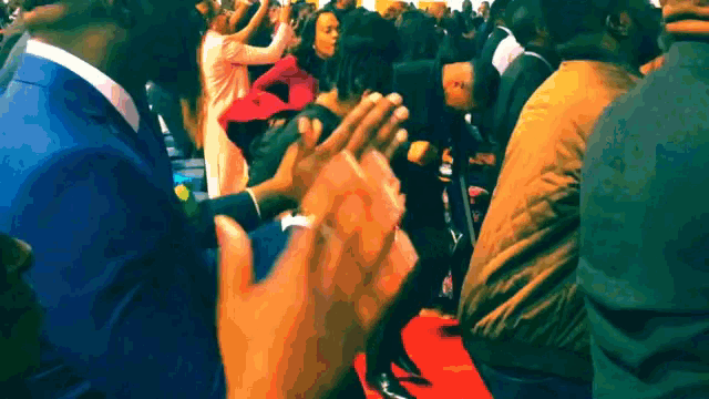 a crowd of people clapping their hands in a crowd