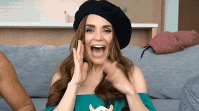 a woman wearing a black beret and a green shirt with horns on it
