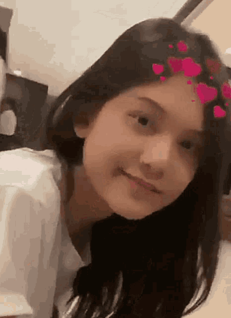 a close up of a girl with hearts on her hair .