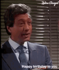 a man in a suit says happy birthday to you