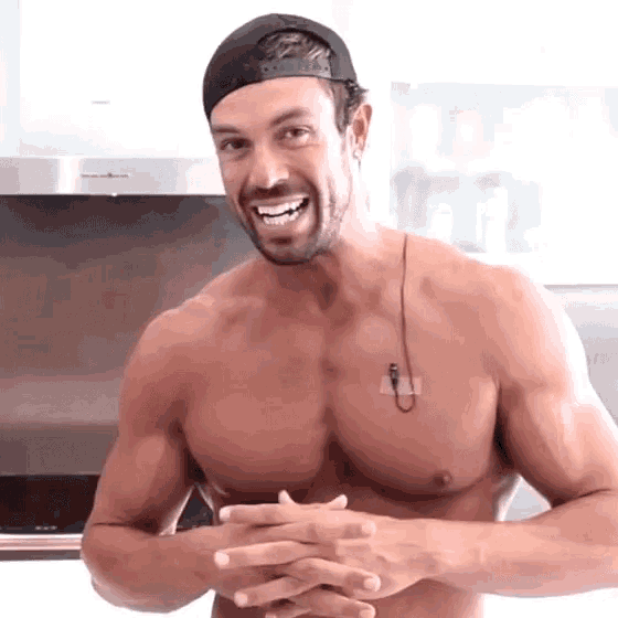 a shirtless man wearing a black baseball cap is smiling