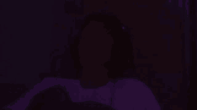 a blurry picture of a person wearing headphones and a microphone in a dark room .