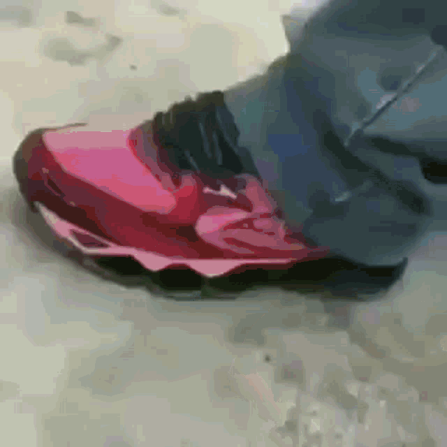 a close up of a person 's foot wearing a red shoe