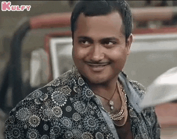 a man wearing a floral shirt and a necklace is smiling and looking at the camera .