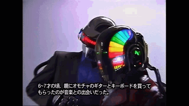 a man in a suit and helmet talks to another man in a helmet