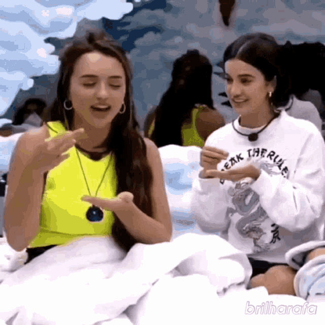 two women are sitting next to each other and one of them is wearing a shirt that says ' freak the rule '