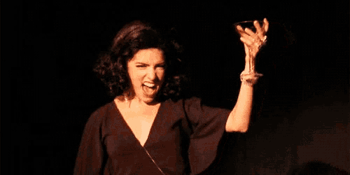 a woman in a black dress is holding something in her hands