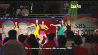 a group of girls are dancing in front of a sbs live sign