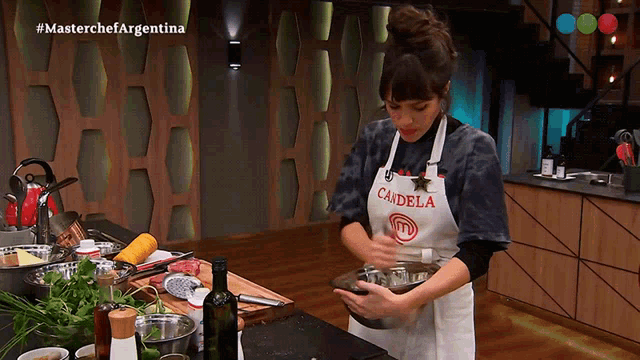 a woman wearing an apron that says cadela on it prepares food in a kitchen