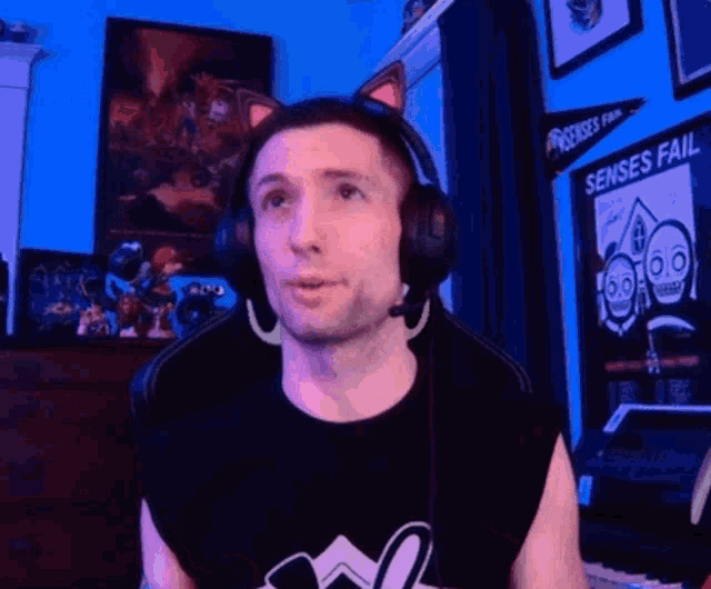 a man wearing headphones with a banner that says senses fail behind him