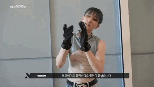 a man wearing black gloves is standing in front of a wall with epixode written on the bottom