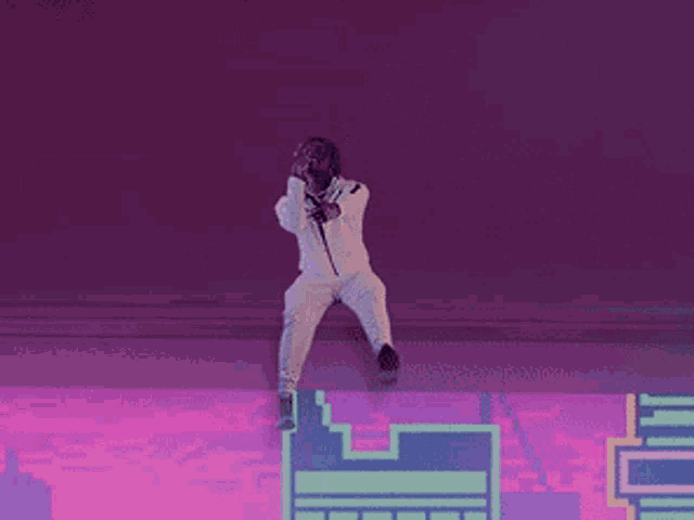 a man is singing into a microphone while standing on a wall