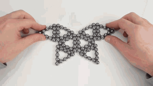 a person is holding a bunch of metal balls