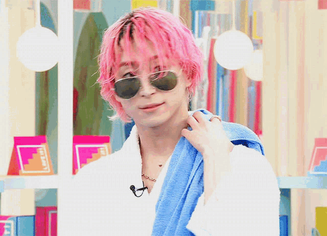 a man with pink hair wearing sunglasses and a towel