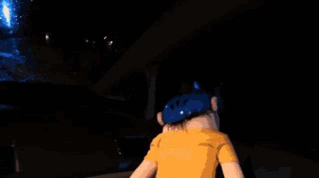 a person is driving a car at night with a blue light coming out of the windshield