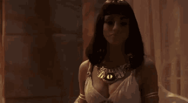 a woman in a white dress and a necklace with a cat 's eye on it .