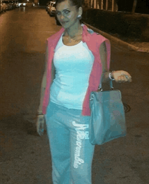 a woman wearing a white tank top and grey sweatpants with abercrombie written on the side