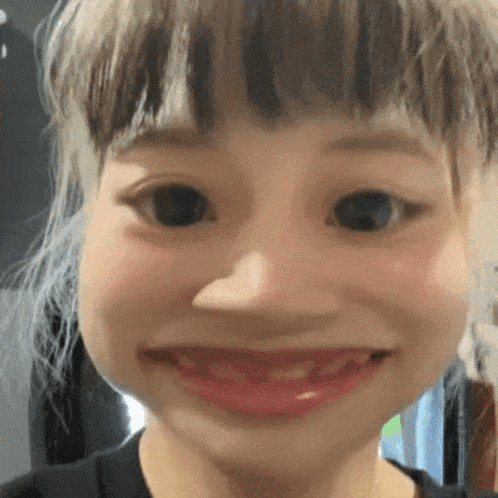 a close up of a girl 's face with a big smile on her face .