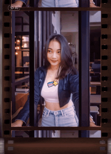 a woman in a crop top with a star on it stands in front of a film strip that says ' ai ' on it
