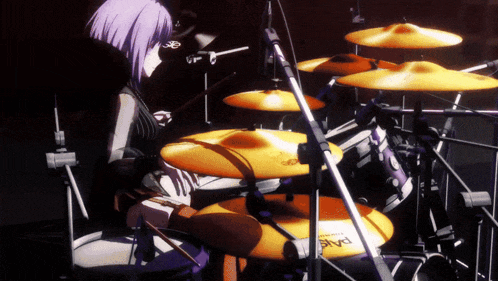 a girl is playing drums with a pair of paiste cymbals in the foreground