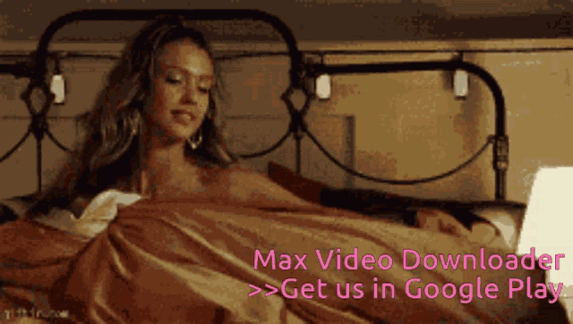 a woman is laying on a bed with the words max video downloader on the bottom