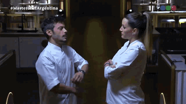 a man and a woman are standing next to each other in a kitchen with the hashtag masterchefargentina