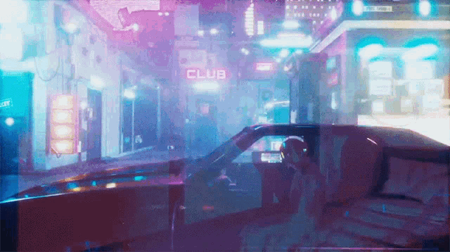 a car is driving down a street with a club sign above it