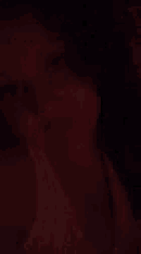 a blurry picture of a woman 's face in the dark