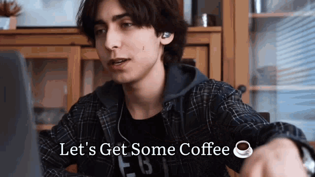 a young man sitting in front of a laptop with the words let 's get some coffee written below him
