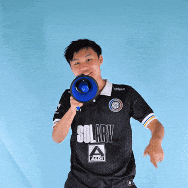 a man wearing a black solary aldi shirt holds a megaphone
