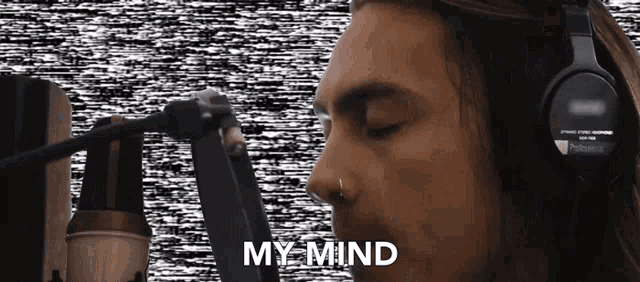 a man wearing headphones is singing into a microphone and the words my mind are visible