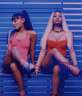 ariana grande and nicki minaj sit on a bench with their legs crossed