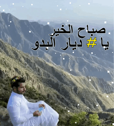 a man sits on top of a mountain with arabic writing on the bottom