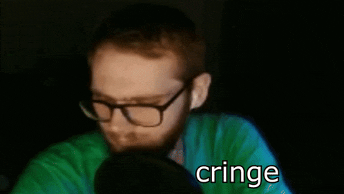 a blurry picture of a man wearing glasses and a green shirt with the word cringe on the bottom
