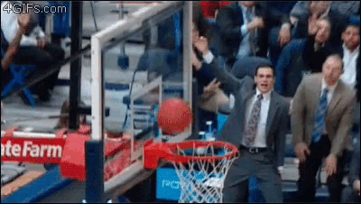 a man in a suit and tie is watching a basketball going through a hoop with a life farm sign behind him