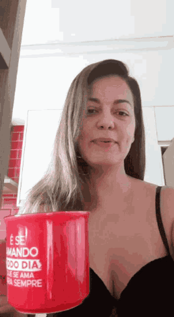 a woman in a black bra is holding a red cup that says ' e se ' on it